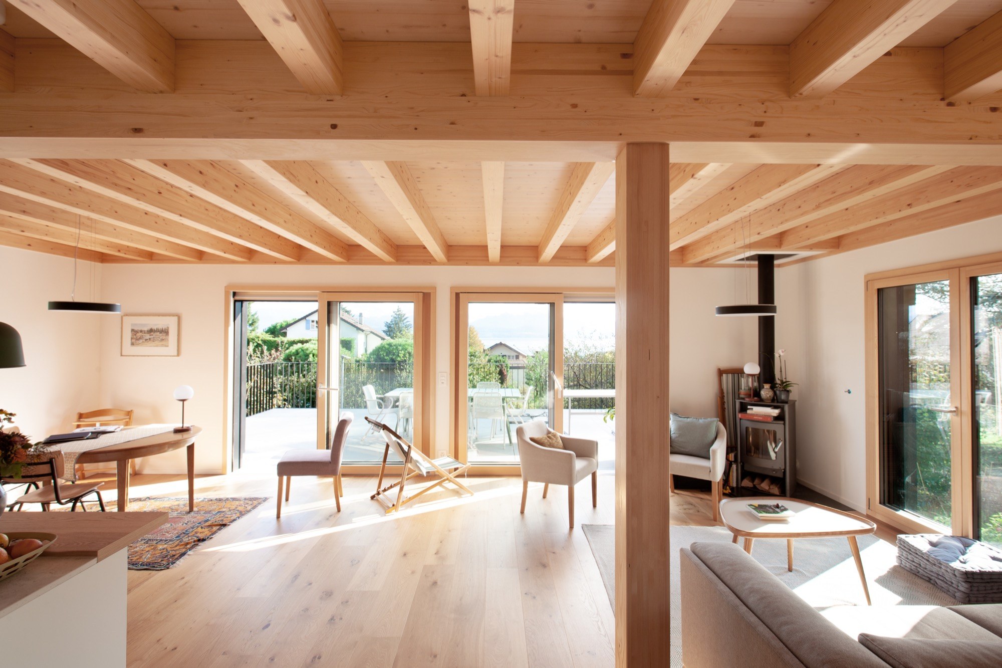 Pièce de vie lumineuse et structure en bois apparente d’une villa à Morges