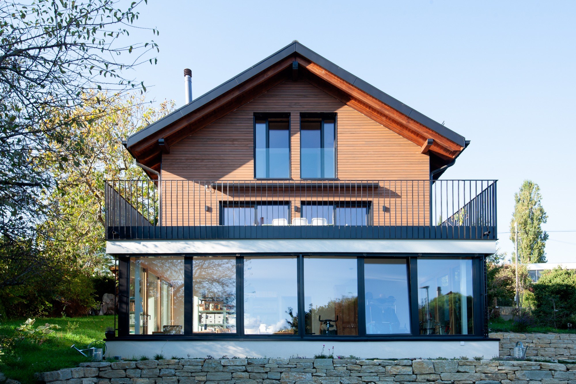 Façade en bois et grandes baies vitrées d’une villa à Morges